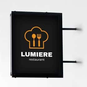 Outdoor black blade sign mounted on a white wall featuring a restaurant logo