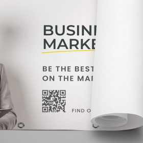 Close-up of a rolled printed banner with a QR code and business graphics.