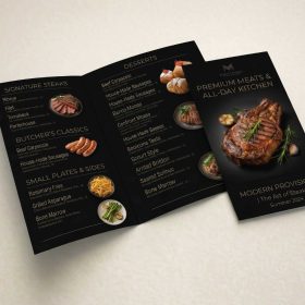 Open black restaurant menu with gold lettering and food photographs.