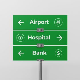 Green directional sign panels for an airport, hospital, and bank on a gray post.