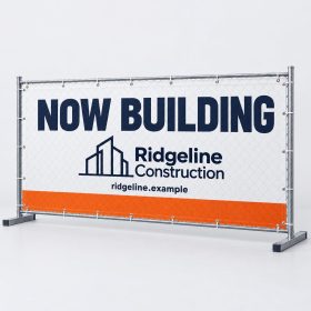 White mesh construction fence wrap reading Now Building on a temporary fence panel