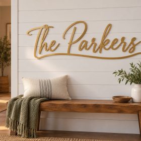 Gold laser cut metal family name sign The Parkers in script mounted on a white shiplap wall above an entry bench