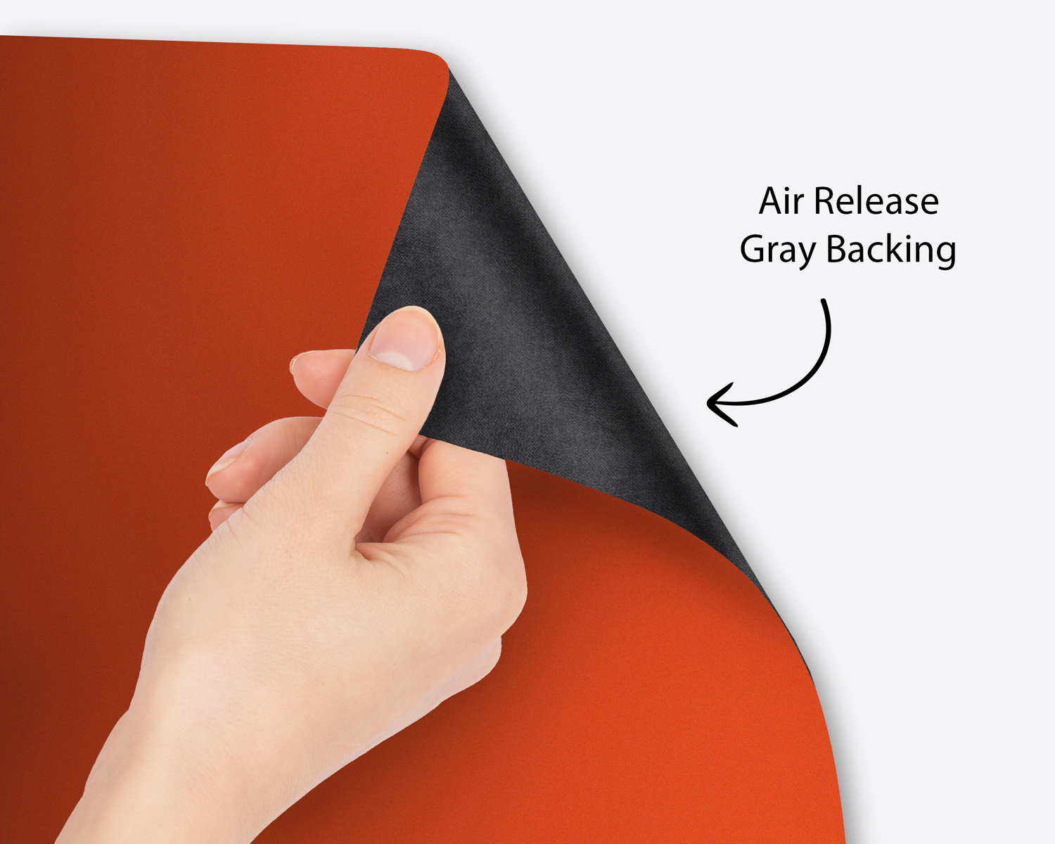 Hand peeling premium vinyl to show the air-release gray backing
